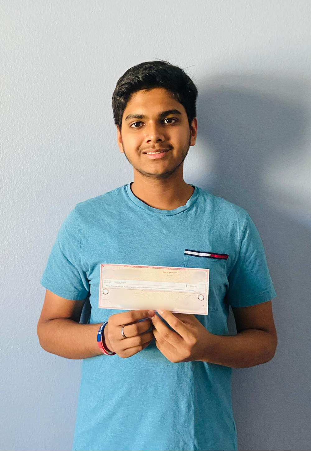Sarthak Gupta holding IT Scholarship Award check