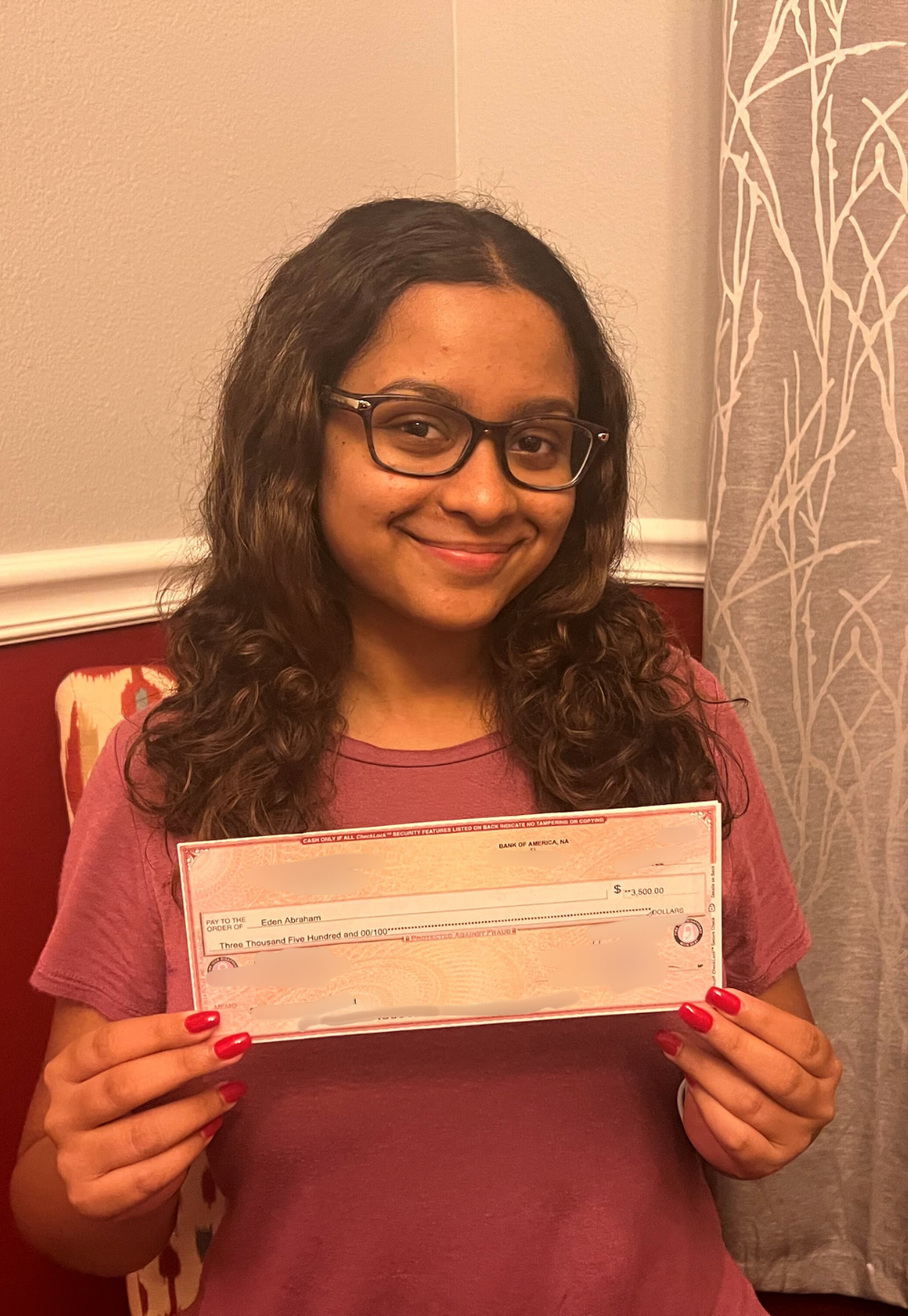 Eden Abrahams holding IT Scholarship Award check