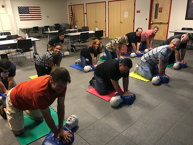 In this picture, a group of employees are learning CPR.