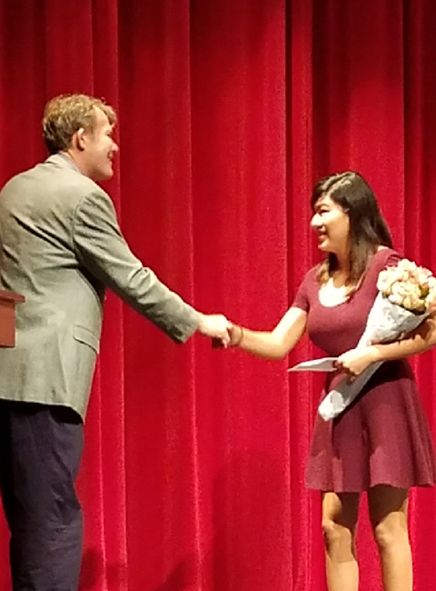 Madeleine Smiley shaking hands with President Paul Toomey while accepting IT Scholarship Award